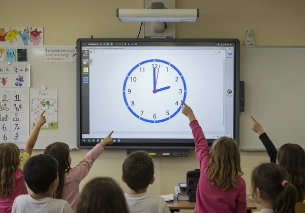 Interactive clock on smartboard, students engaged.
